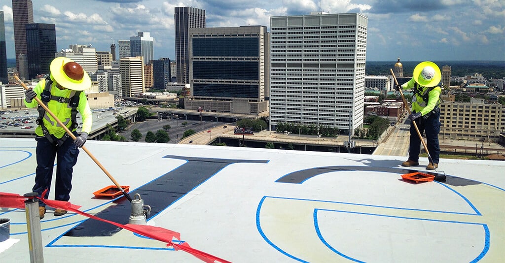 Roof Logo workers high atop the city of Atlanta painting on the logo of the Mercedes-Benz Stadium